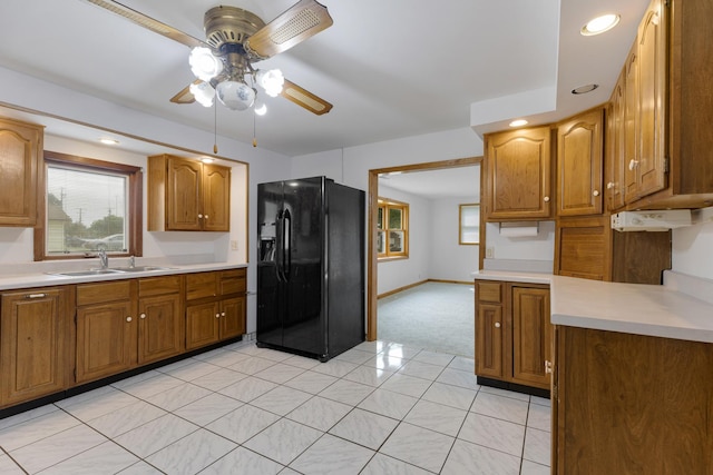 510 S Sycamore St, Genoa, IL 60135 - kitchen with black fridge with ice dispenser, a sink, ceiling fan, brown cabinetry, and light countertops