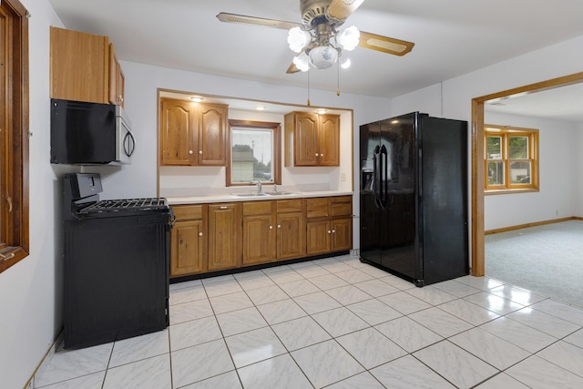 510 S Sycamore St, Genoa, IL 60135 - kitchen featuring black appliances, a sink, ceiling fan, brown cabinetry, and light countertops