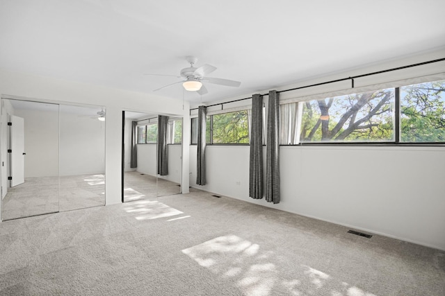 924 S May St, Chicago, IL 60607 - unfurnished bedroom with multiple closets, carpet flooring, and a ceiling fan