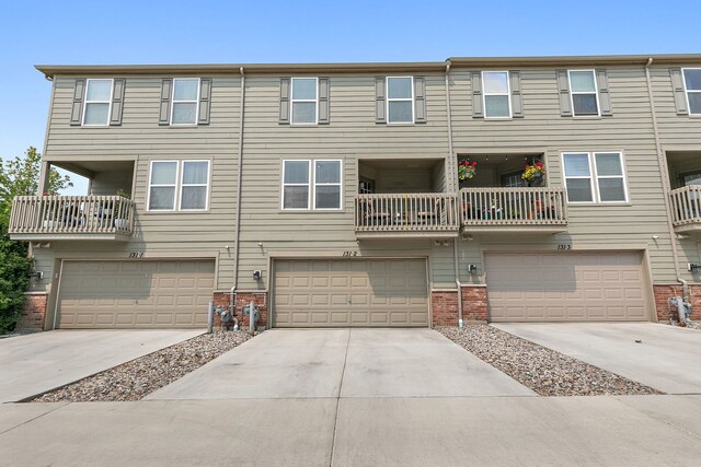 131 Bristol Ln Unit 2, Wood Dale, IL 60191 - back of property with brick siding, a garage, and driveway