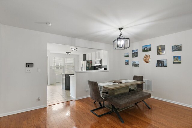 131 Bristol Ln Unit 2, Wood Dale, IL 60191 - dining area with a chandelier, light wood-type flooring, and baseboards