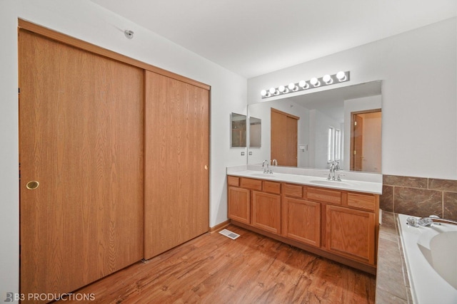6520 Bridle Path Dr, Matteson, IL 60443 - full bath with double vanity, a bathtub, and wood finished floors