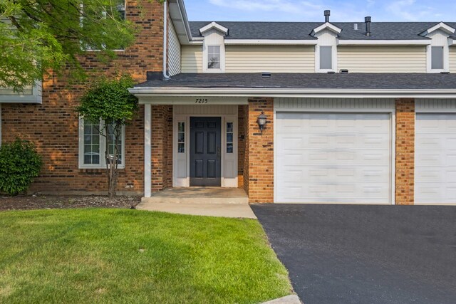 7215 Birchwood Ct Unit 19B, Willowbrook, IL 60527 - view of front of property featuring brick siding, a front yard, a garage, and driveway