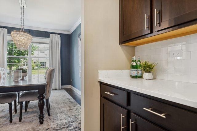 819 Heatherfield Cir, Naperville, IL 60565 - dining space with crown molding, a chandelier, and baseboards