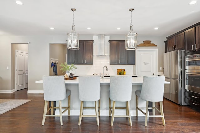 819 Heatherfield Cir, Naperville, IL 60565 - kitchen featuring appliances with stainless steel finishes, wall chimney exhaust hood, a kitchen island with sink, light countertops, and backsplash