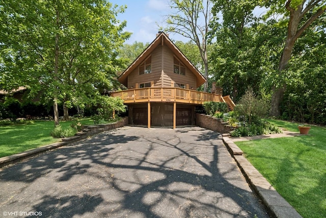 11214 Halma Ln, Woodstock, IL 60098 - chalet / cabin with asphalt driveway, a wooden deck, a front yard, and an attached garage