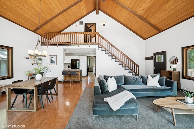 11214 Halma Ln, Woodstock, IL 60098 - living room featuring a wood ceiling with exposed beams, high vaulted ceiling, wood finished floors, stairs, and a chandelier