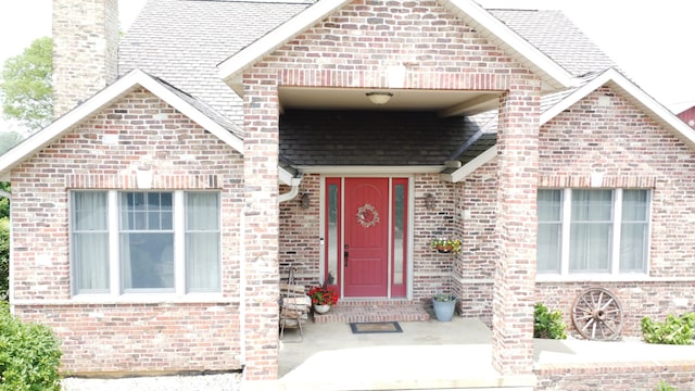 1897 N 2500 E Rd, Watseka, IL 60970 - property entrance featuring brick siding, a shingled roof, and a chimney