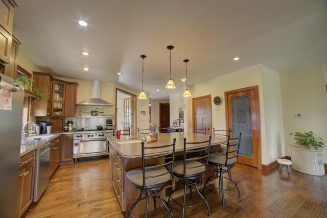 1897 N 2500 E Rd, Watseka, IL 60970 - kitchen with wall chimney exhaust hood, wood finished floors, stainless steel appliances, light countertops, and a breakfast bar area