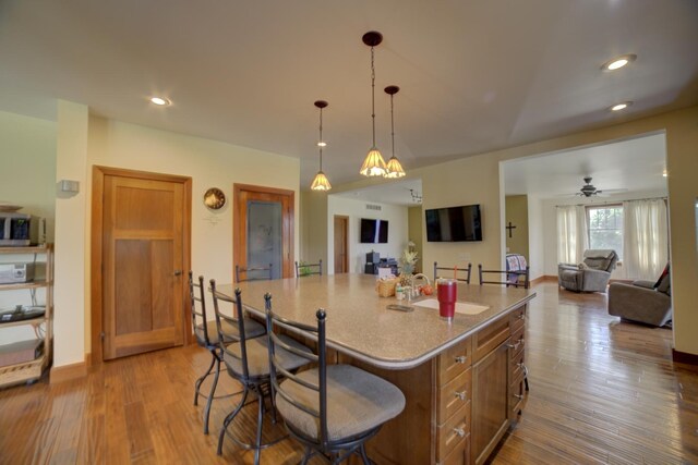 1897 N 2500 E Rd, Watseka, IL 60970 - kitchen featuring open floor plan, a breakfast bar, a center island, wood finished floors, and pendant lighting