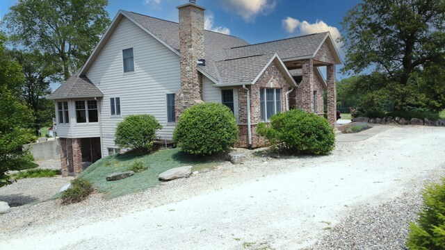 1897 N 2500 E Rd, Watseka, IL 60970 - view of side of property featuring brick siding, a chimney, and a shingled roof
