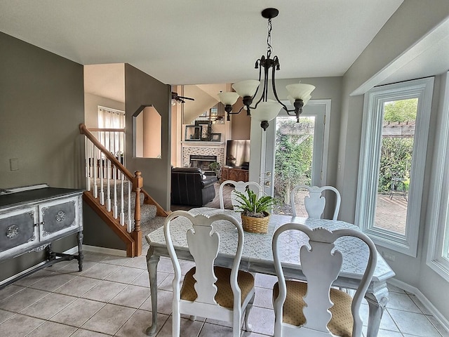 23243 S Volbrecht Rd, Crete, IL 60417 - dining room featuring light tile patterned floors, stairway, baseboards, a tiled fireplace, and a chandelier