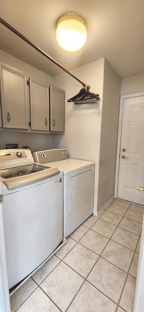 23243 S Volbrecht Rd, Crete, IL 60417 - washroom featuring cabinet space, washer and dryer, light tile patterned flooring, and baseboards