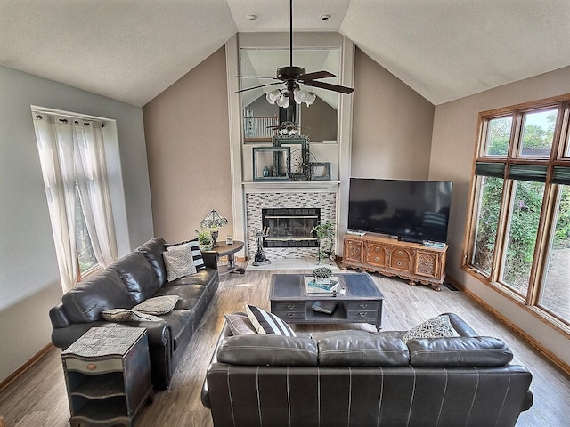 23243 S Volbrecht Rd, Crete, IL 60417 - living area with lofted ceiling, a ceiling fan, a tiled fireplace, wood finished floors, and baseboards