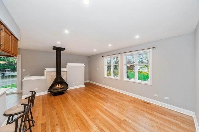608 Inverrary Ln Unit 608, Deerfield, IL 60015 - unfurnished living room with a wood stove, light wood finished floors, recessed lighting, and baseboards