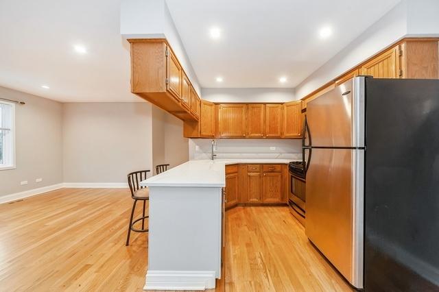 608 Inverrary Ln Unit 608, Deerfield, IL 60015 - kitchen with appliances with stainless steel finishes, a peninsula, light wood finished floors, a kitchen breakfast bar, and recessed lighting