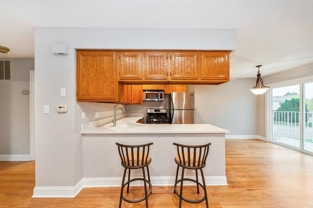 608 Inverrary Ln Unit 608, Deerfield, IL 60015 - kitchen featuring appliances with stainless steel finishes, a sink, a peninsula, light wood finished floors, and light countertops
