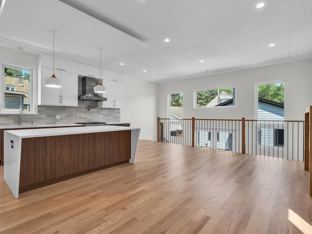 4845 N Mcvicker Ave, Chicago, IL 60630 - kitchen with wall chimney exhaust hood, white cabinets, light wood-type flooring, light countertops, and recessed lighting