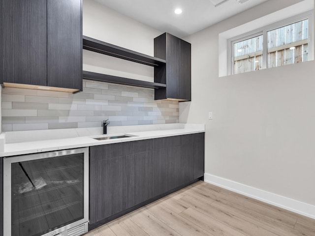 4845 N Mcvicker Ave, Chicago, IL 60630 - kitchen featuring beverage cooler, open shelves, light countertops, light wood finished floors, and decorative backsplash