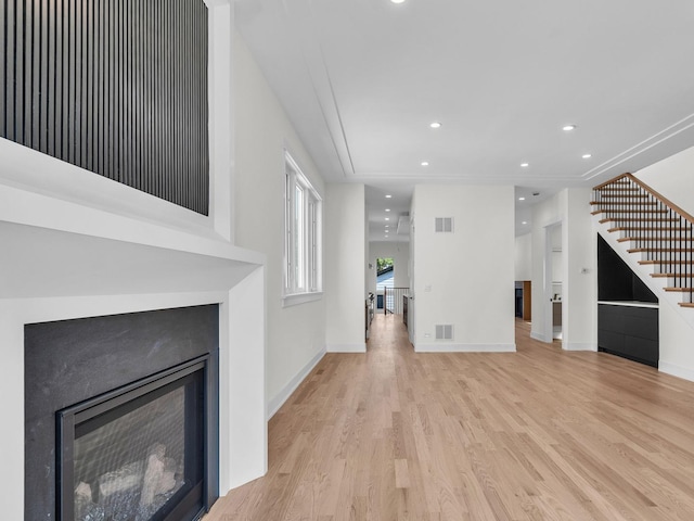 4845 N Mcvicker Ave, Chicago, IL 60630 - unfurnished living room featuring wood finished floors, a glass covered fireplace, stairs, and recessed lighting