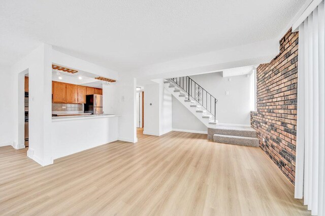 9830 Sayre Ave Unit 7, Chicago Ridge, IL 60415 - unfurnished living room with light wood-style flooring, stairs, baseboards, and brick wall