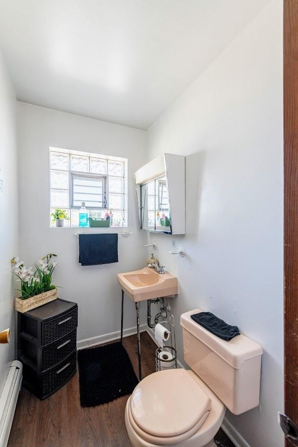 1619 N 35th Ave, Melrose Park, IL 60160 - bathroom featuring a baseboard radiator, wood finished floors, toilet, baseboards, and a sink
