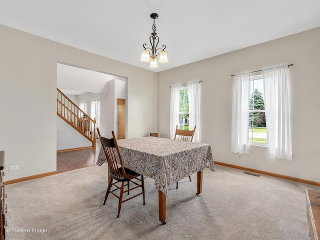 1665 Whispering Oaks Ct, West Chicago, IL 60185 - dining room with carpet floors, stairs, and a chandelier