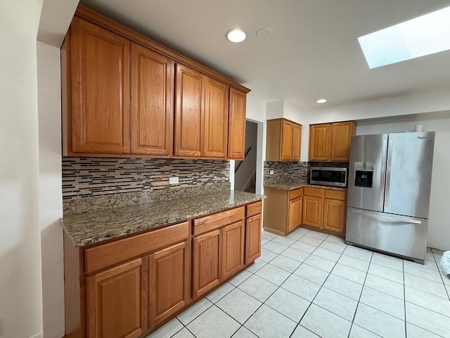 572 N Emroy Ave, Elmhurst, IL 60126 - kitchen with appliances with stainless steel finishes, a skylight, brown cabinets, decorative backsplash, and light tile patterned flooring