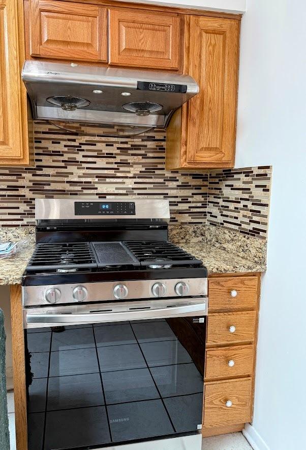 572 N Emroy Ave, Elmhurst, IL 60126 - kitchen with gas stove, under cabinet range hood, backsplash, tile patterned flooring, and light stone counters