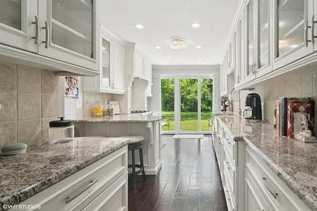 231 N Forest Ct, Addison, IL 60101 - kitchen featuring dark wood-type flooring, light stone countertops, white cabinets, decorative backsplash, and recessed lighting