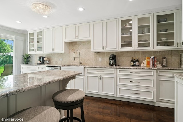 231 N Forest Ct, Addison, IL 60101 - kitchen featuring a sink, ornamental molding, dark wood-style floors, white cabinets, and light stone countertops