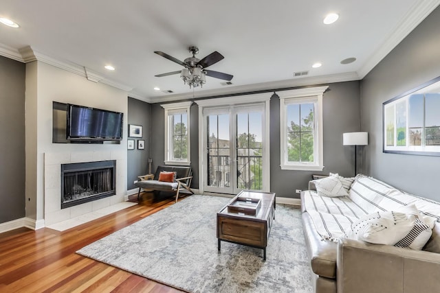 2709 W Bryn Mawr Ave Unit 4, Chicago, IL 60659 - living area with ornamental molding, wood finished floors, a ceiling fan, a tiled fireplace, and baseboards