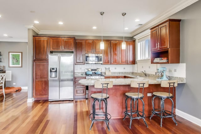 2709 W Bryn Mawr Ave Unit 4, Chicago, IL 60659 - kitchen with stainless steel appliances, a peninsula, a sink, crown molding, and wood finished floors