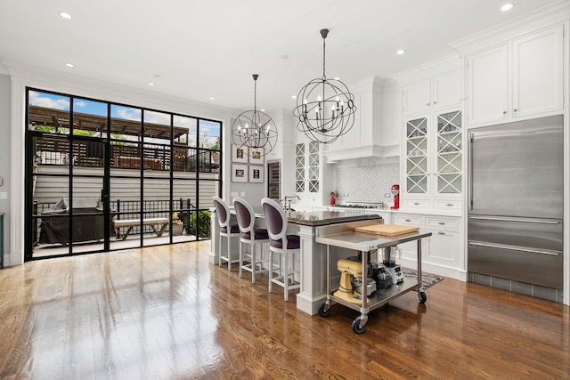 2429 W Belden Ave, Chicago, IL 60647 - kitchen with built in fridge, ornamental molding, white cabinetry, wood finished floors, and a chandelier