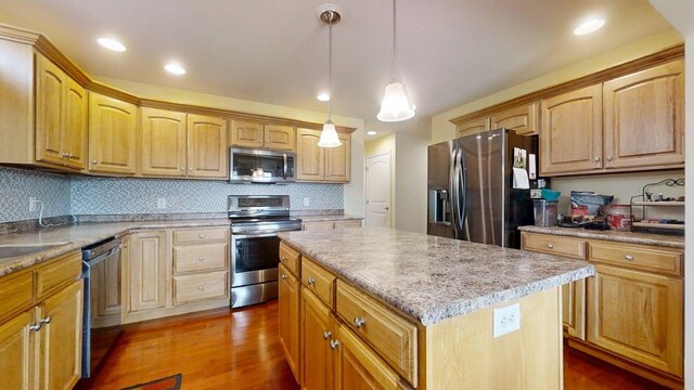 4005 Pebblebrook Ln, Champaign, IL 61822 - kitchen featuring appliances with stainless steel finishes, a kitchen island, dark wood finished floors, tasteful backsplash, and light countertops