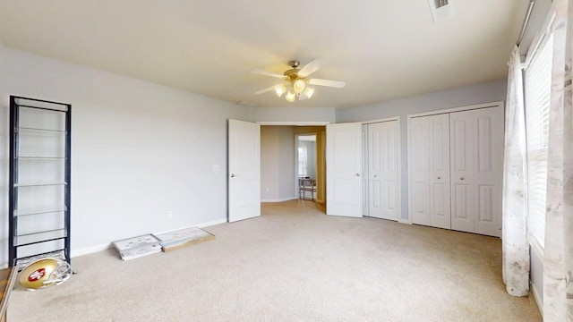 4005 Pebblebrook Ln, Champaign, IL 61822 - unfurnished bedroom featuring two closets, light colored carpet, and ceiling fan