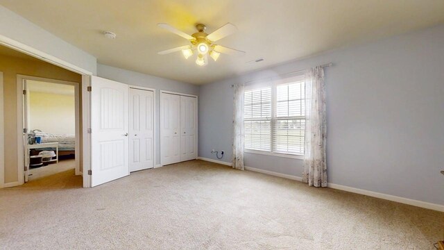 4005 Pebblebrook Ln, Champaign, IL 61822 - unfurnished bedroom with multiple closets, carpet floors, and ceiling fan
