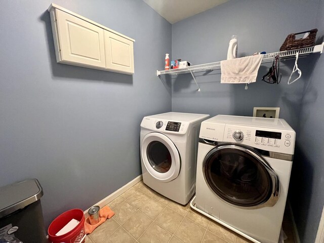 4005 Pebblebrook Ln, Champaign, IL 61822 - laundry area featuring separate washer and dryer, light tile patterned flooring, and cabinet space