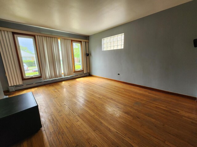 7112 W Farragut Ave, Chicago, IL 60656 - spare room with a baseboard heating unit, hardwood / wood-style flooring, and baseboards