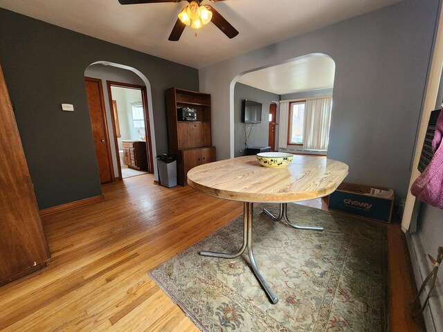 7112 W Farragut Ave, Chicago, IL 60656 - dining room with arched walkways, ceiling fan, and light wood-type flooring
