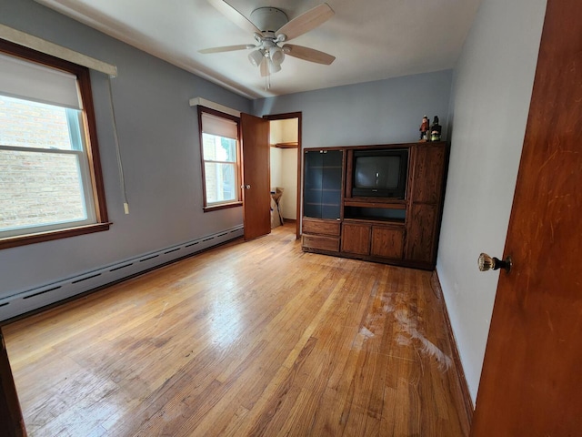 7112 W Farragut Ave, Chicago, IL 60656 - unfurnished living room with healthy amount of natural light, light wood-style flooring, ceiling fan, and a baseboard radiator
