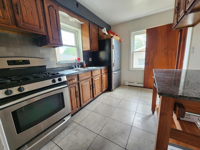 7112 W Farragut Ave, Chicago, IL 60656 - kitchen with stainless steel appliances, a baseboard heating unit, a sink, and plenty of natural light