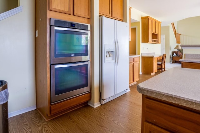 400 Bower Ln, Oswego, IL 60543 - kitchen with white fridge with ice dispenser, double oven, wood finished floors, and baseboards