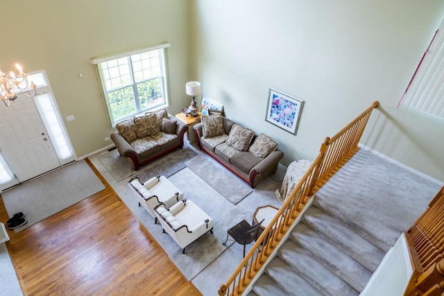 400 Bower Ln, Oswego, IL 60543 - living area featuring wood finished floors, a chandelier, a towering ceiling, and baseboards