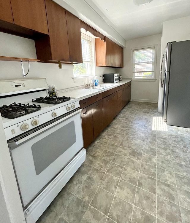 1140 Blanchan Ave, La Grange Park, IL 60526 - kitchen featuring appliances with stainless steel finishes, healthy amount of natural light, a sink, and open shelves