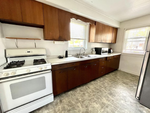 1140 Blanchan Ave, La Grange Park, IL 60526 - kitchen with white appliances, a sink, light countertops, baseboards, and dark brown cabinets