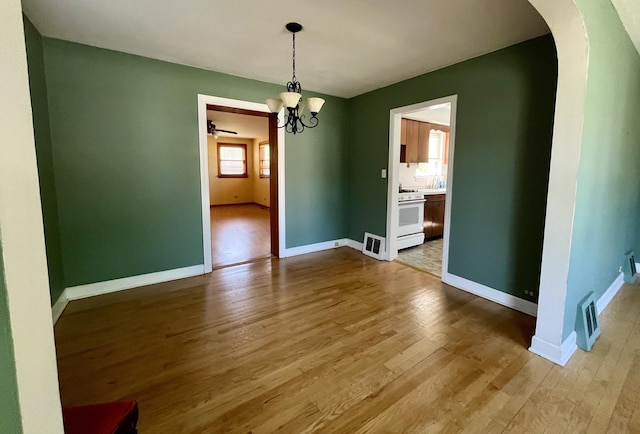 1140 Blanchan Ave, La Grange Park, IL 60526 - unfurnished dining area with arched walkways, wood finished floors, a chandelier, and baseboards