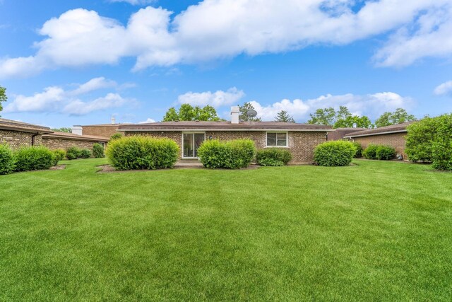 2240 Vista Ct, Northbrook, IL 60062 - back of house featuring brick siding, a lawn, and a chimney
