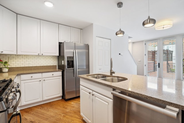 2417 N Janssen Ave Unit C, Chicago, IL 60614 - kitchen featuring stainless steel appliances, a sink, light wood finished floors, decorative backsplash, and white cabinetry