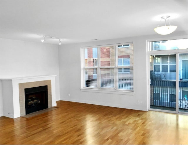 2231 W Maypole Ave Unit 201, Chicago, IL 60612 - unfurnished living room featuring track lighting, wood finished floors, and a tiled fireplace